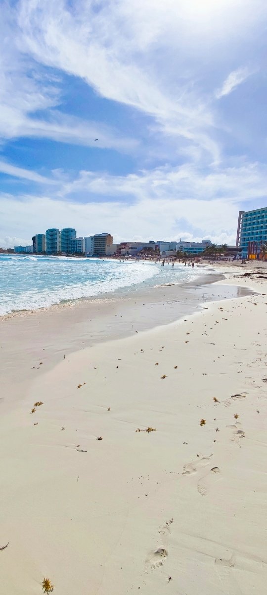 Vista hacia la playa con sus olas calmadas, cristalinas y al fondo los hoteles de la zona en Playa Gaviota Azul (Fórum). © 2024 Castor Daniel Oregel Maldonado